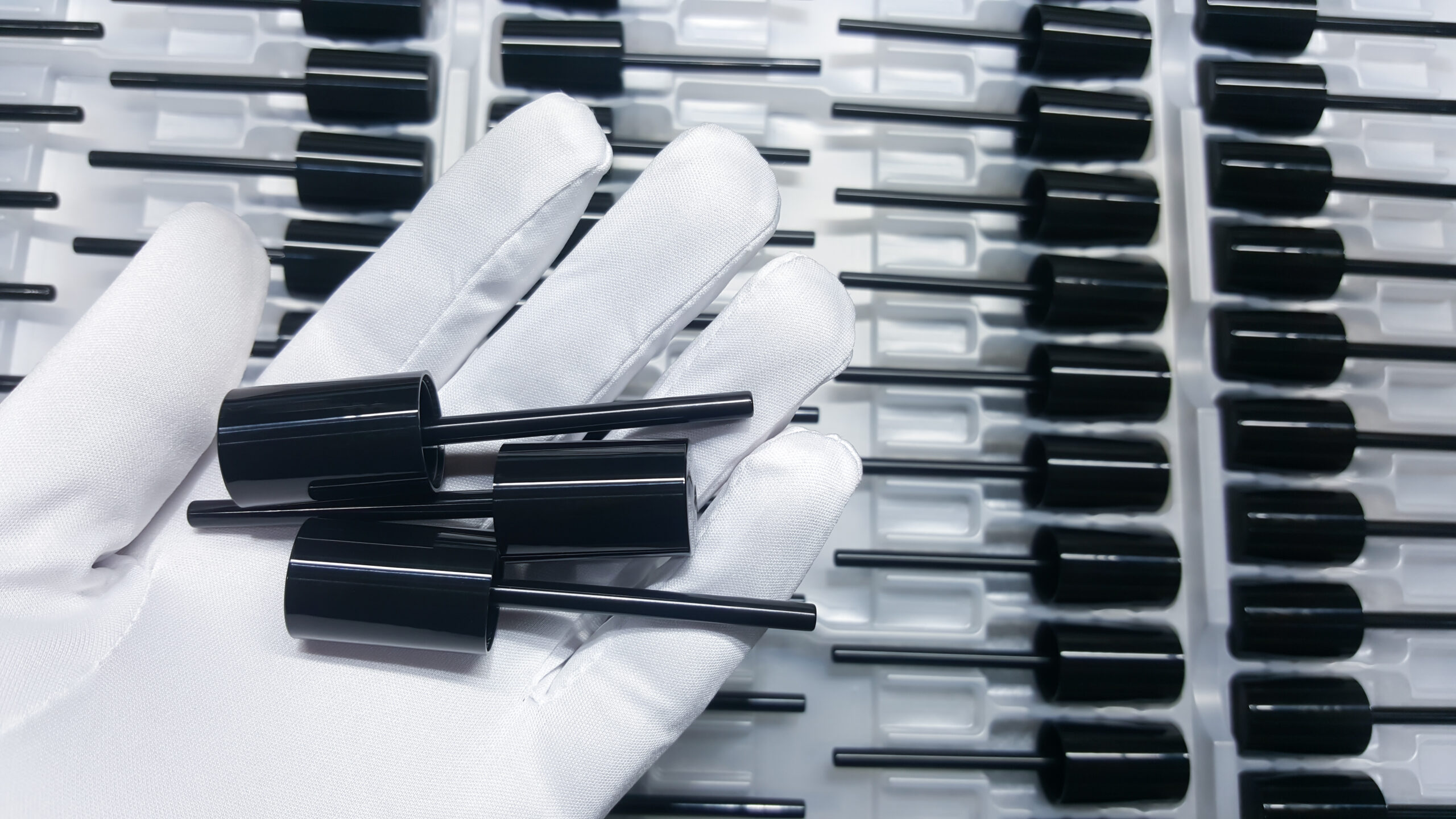 Photos of black lipstick caps, parts of cosmetic plastic products, from the industrial plastic production department.