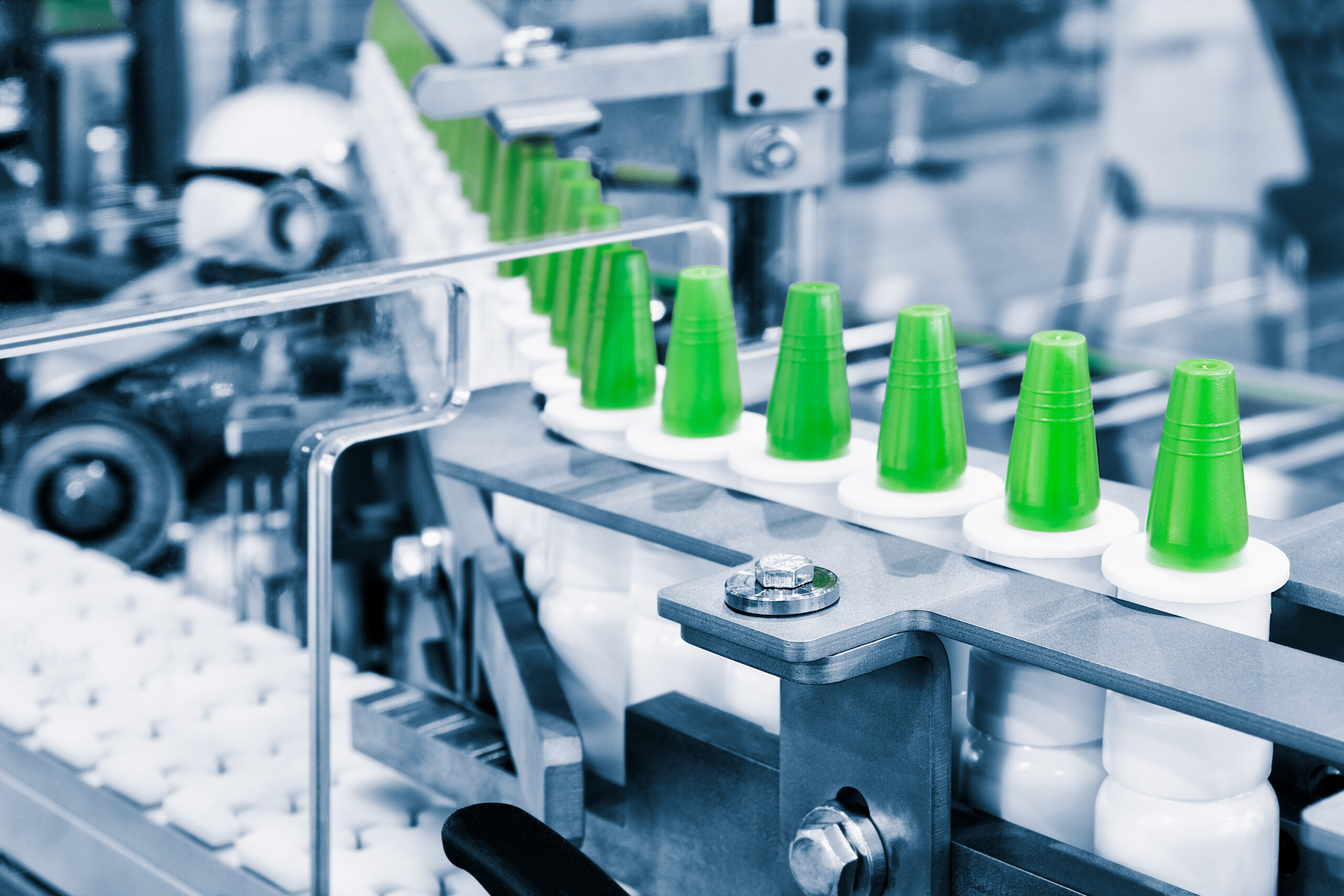 Close-up Many white plastic spray bottles for packaging liquid medicines or cosmetics in a row on a conveyor belt in a pharmaceutical manufacturing factory